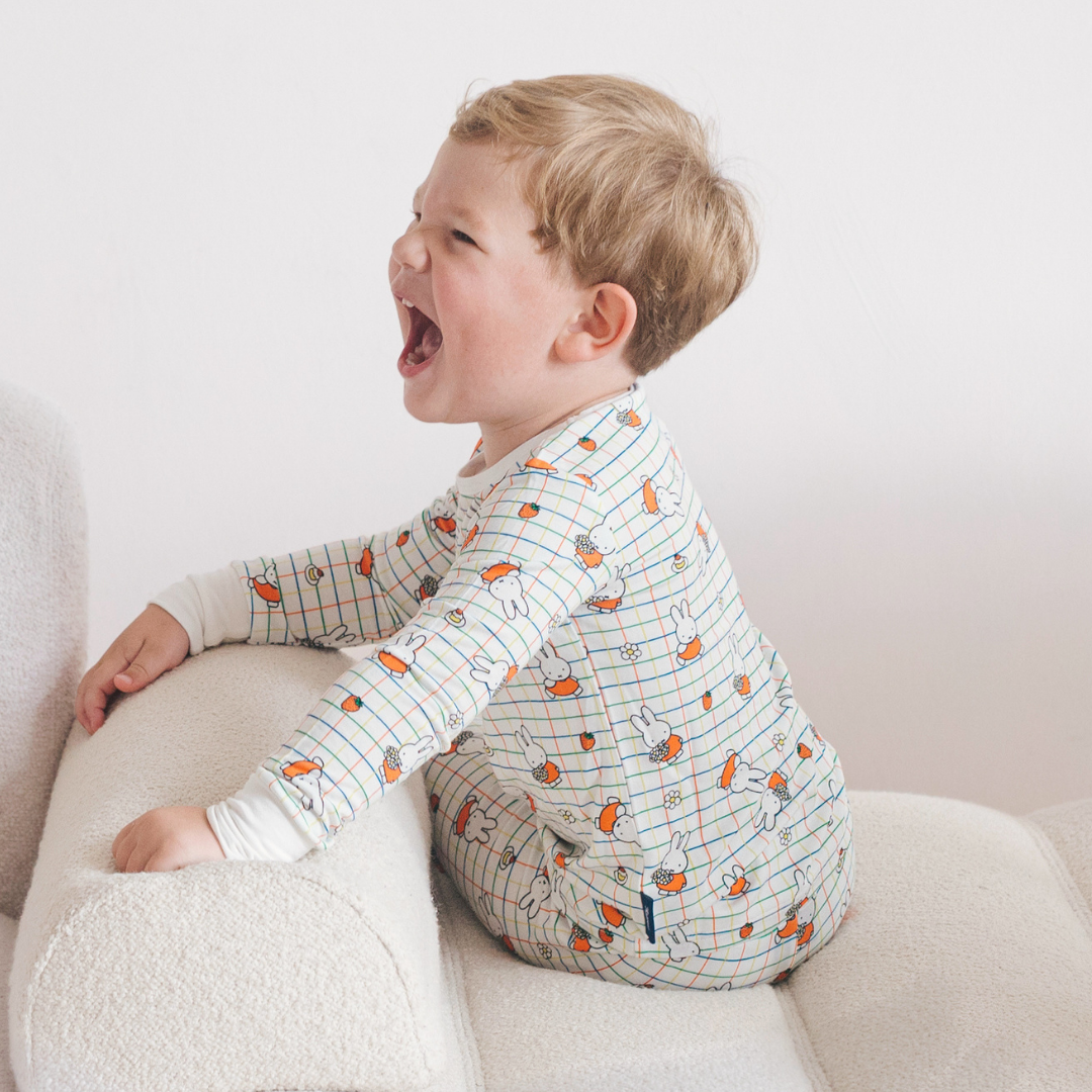 Kind dat de nijntje Checkered Bloom bamboe-pyjamaset voor kinderen draagt