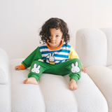 Kind dat de nijntje on the Move-bamboe-loungeset draagt, bestaande uit een fiets-sweatshirt en een groene joggingbroek
