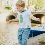 Kind dat het witte nijntje kinder-T-shirt met groene nijntje opdruk draagt