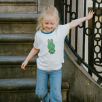 Kind dat het witte nijntje kinder-T-shirt met groene nijntje opdruk draagt