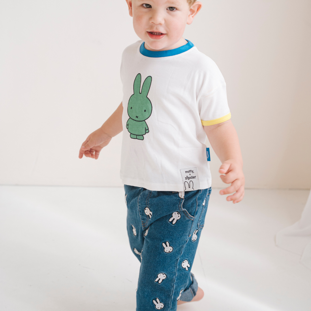 Kind dat het witte nijntje kinder-T-shirt met groene nijntje opdruk draagt