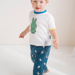 Kind dat het witte nijntje kinder-T-shirt met groene nijntje opdruk draagt