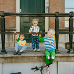Kind dat de nijntje on the Move-bamboe-loungeset draagt, bestaande uit een fiets-sweatshirt en een groene joggingbroek