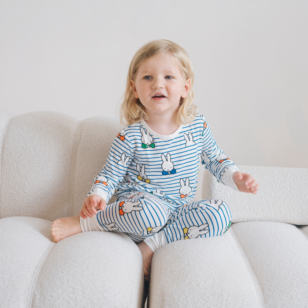 Kind dat de nijntje Peek-a-Boo Blue bamboe-pyjamaset voor kinderen draagt