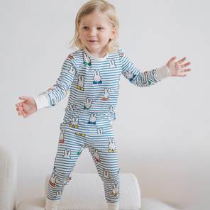 Kind dat de nijntje Peek-a-Boo Blue bamboe-pyjamaset voor kinderen draagt