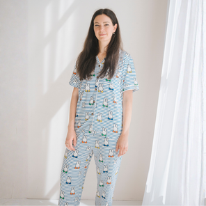 Vrouw die de damespyjamaset nijntje Peek-a-Boo Blue van bamboe draagt