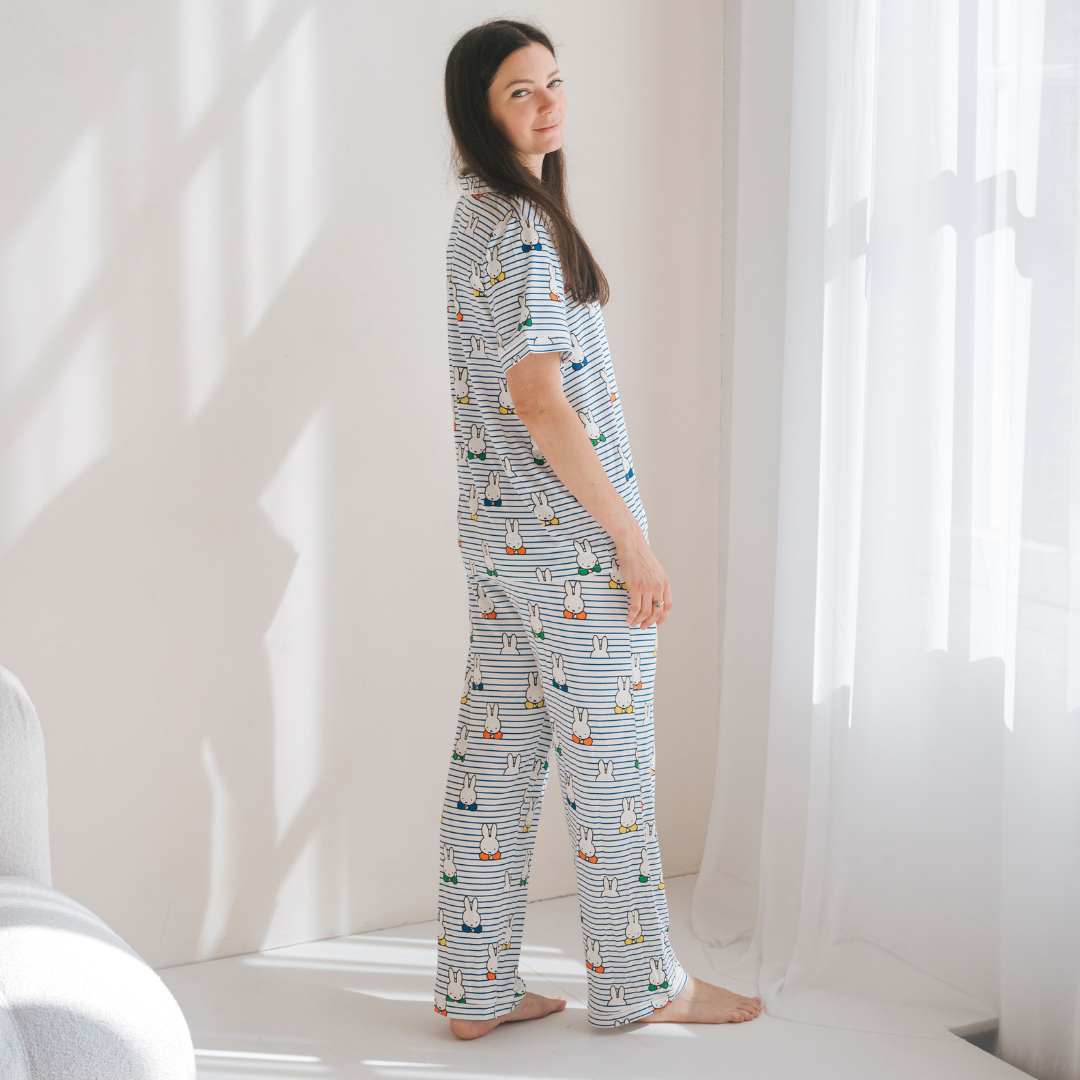 Vrouw die de damespyjamaset nijntje Peek-a-Boo Blue van bamboe draagt