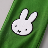 Ontwerpdetail van de nijntje uit de Move-bamboe loungeset, met een fiets-sweatshirt en een groene joggingbroek