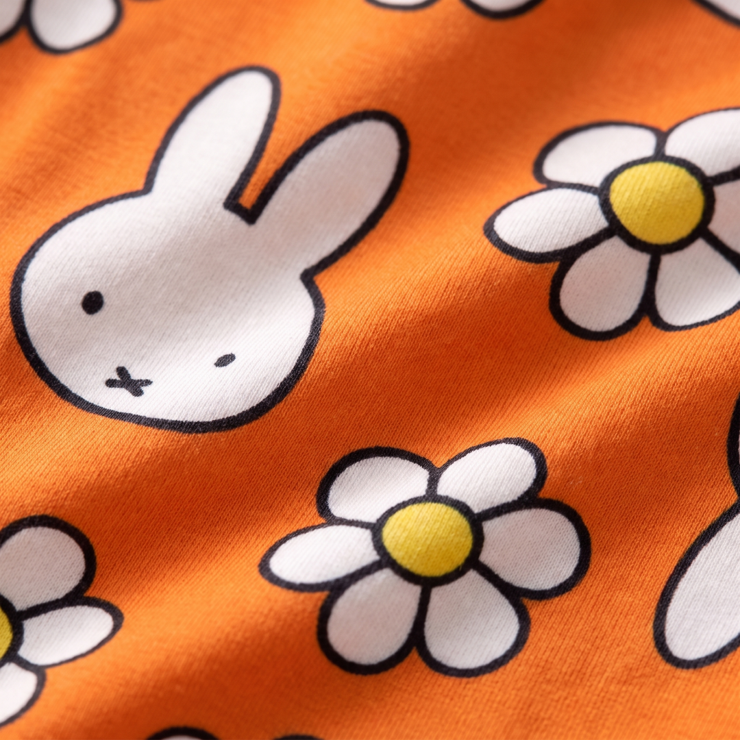 Close-up van de zachte bamboestof van het ZIPSTER x nijntje Daisy Days bamboe-rompertje